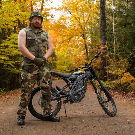 Handsome camoflauged man standing in front of E Ride Pro SS 2.0 Electric Bike